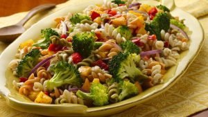 dressing the vegetable in pasta salad